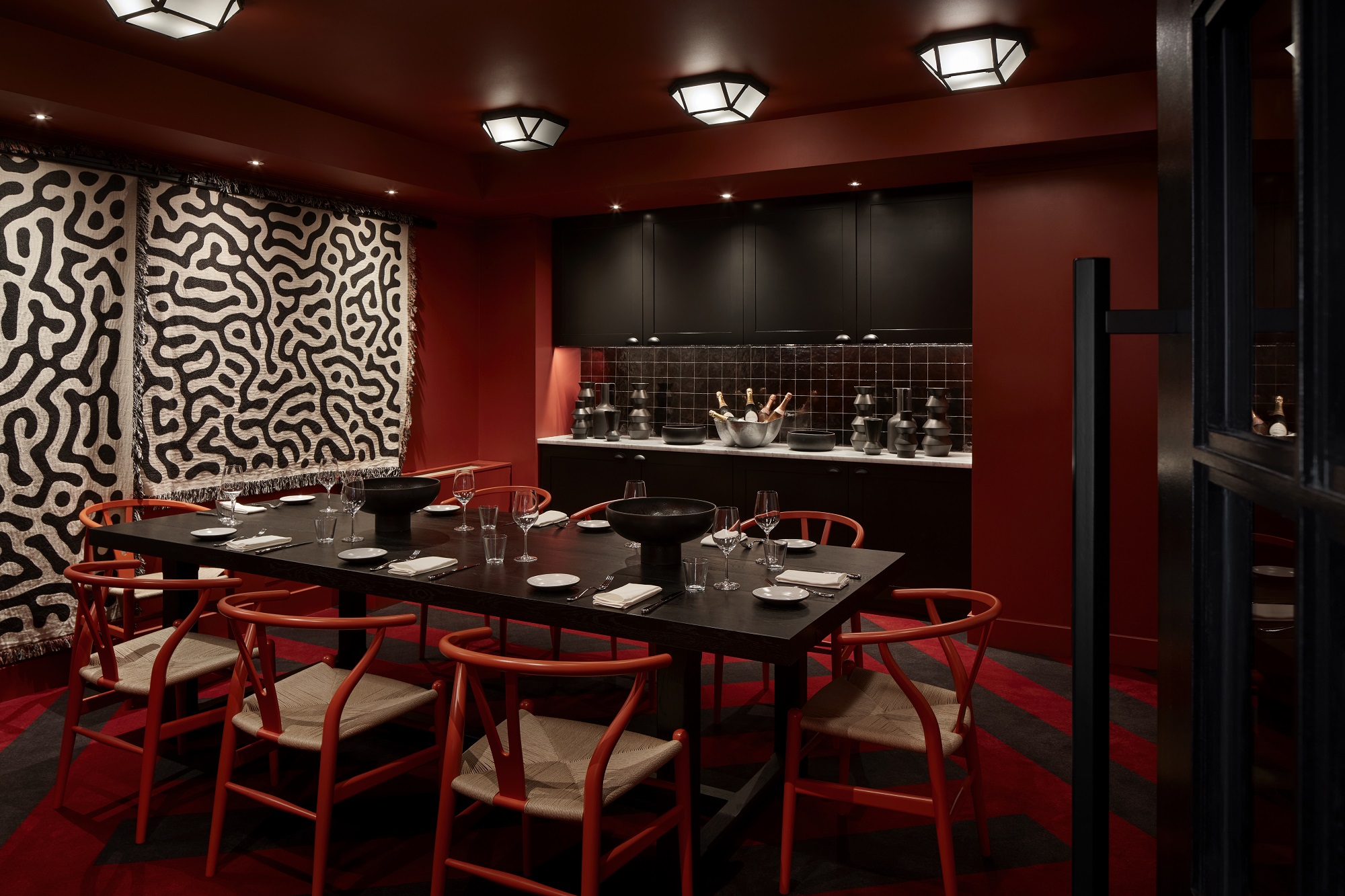 Dining area with table set for a dinner party in a dimly lit private dining area at Lyle DC.