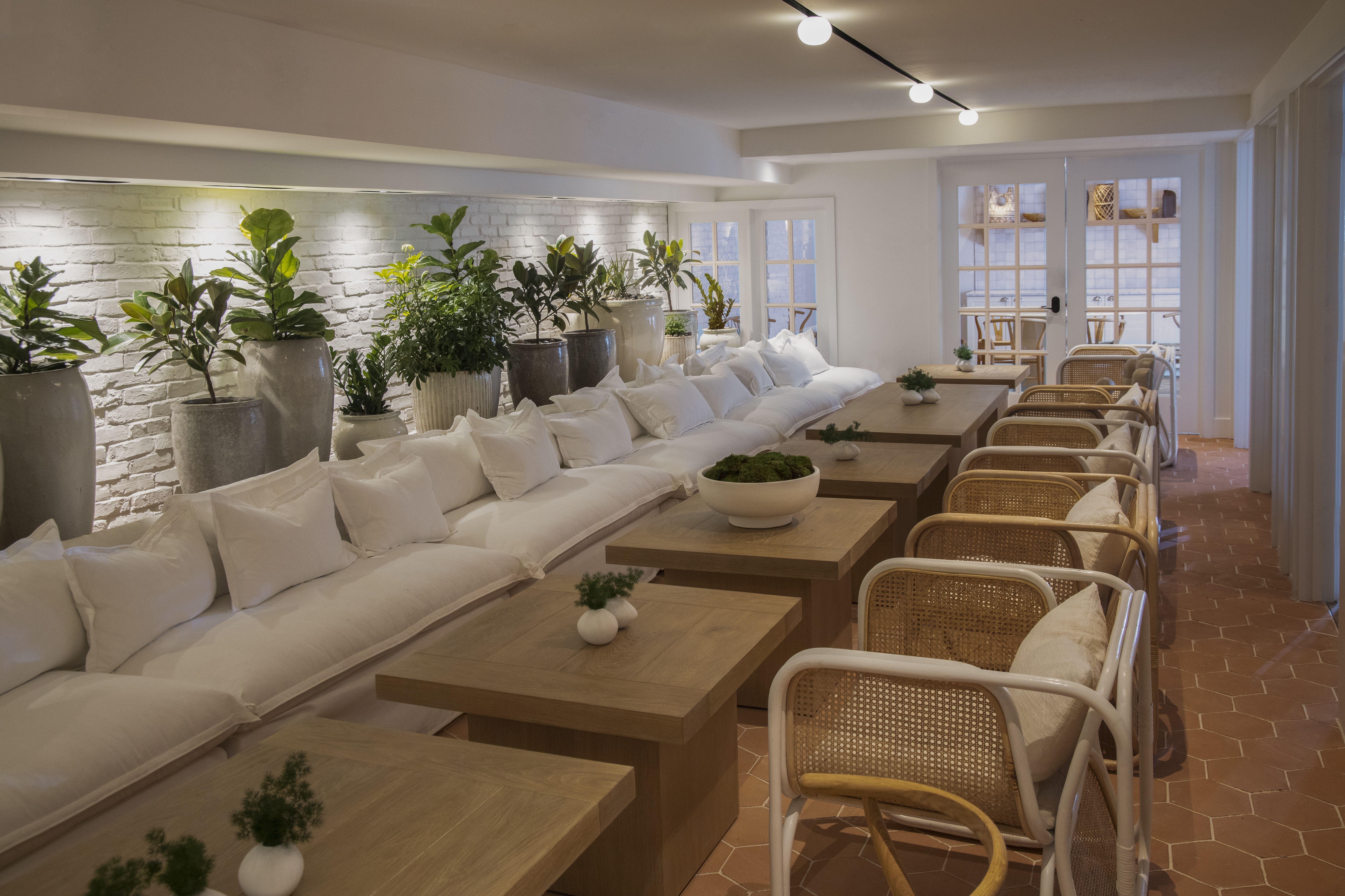 The Conservatory row of wooden table and white chairs.