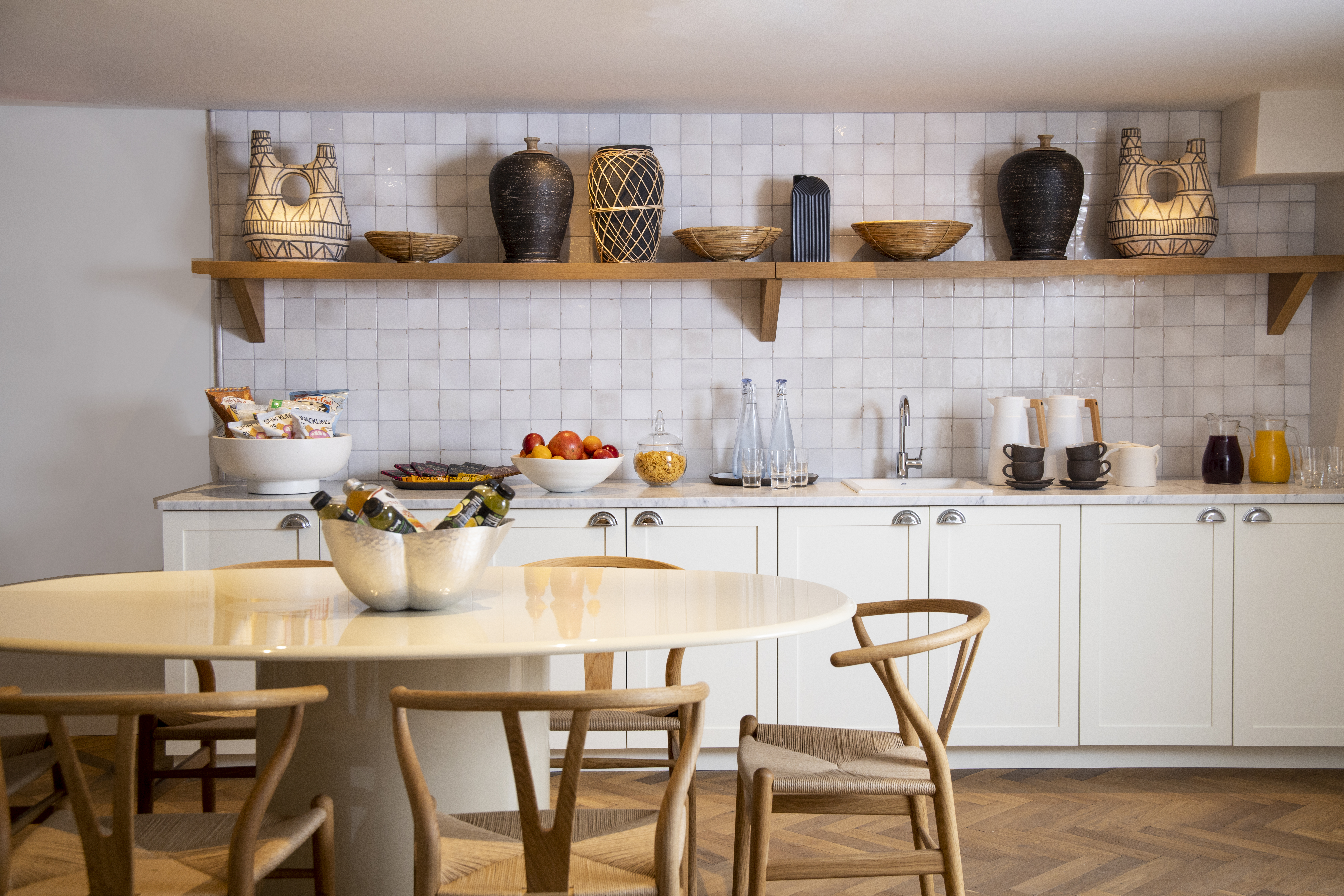 The Pantry kitchen with a wooden table and white wall tiles.